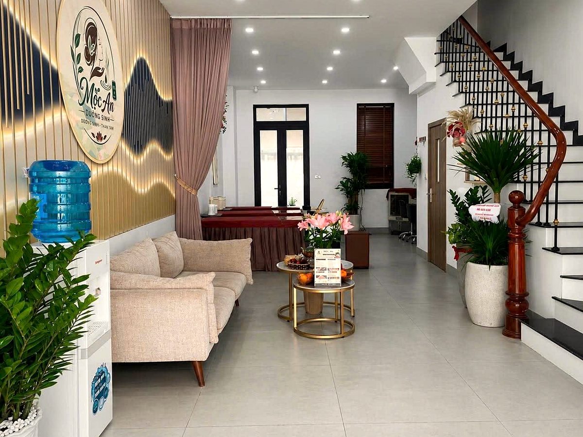 Sảnh đón khách Mộc An Dưỡng Sinh với sofa, hoa và logo trên tường